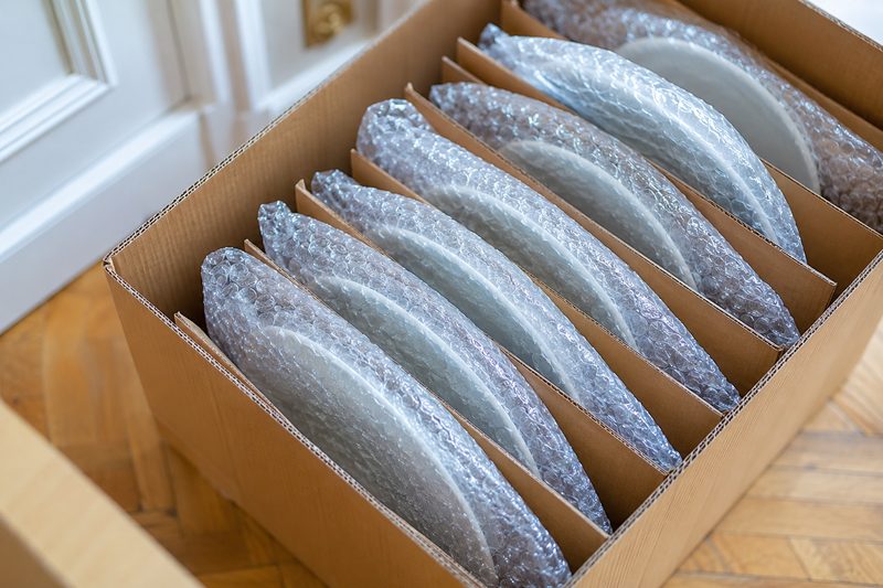 Vaisselle emballée une à une dans un carton à compartiments