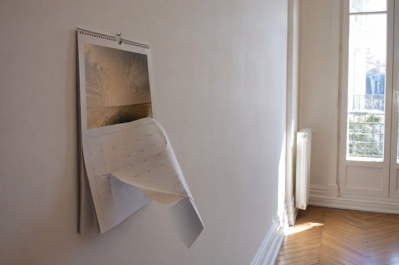 Calendrier mural sur un mur nu, page à demi arrachée