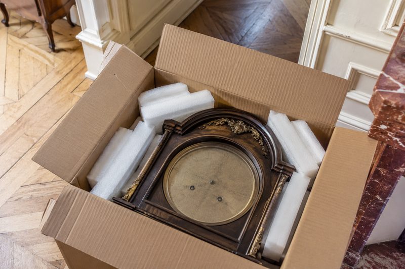 Pendule ancienne calée dans un carton pour un déménagement accompagné