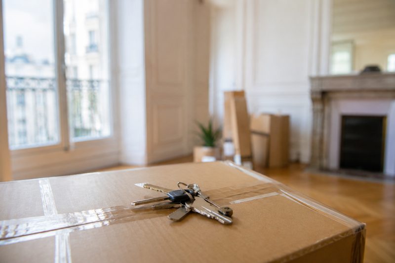 Trousseau de clés posé sur un carton fermé le jour du départ